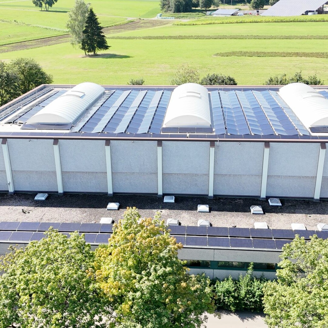 Photovoltaik-System auf einer Sporthalle im Sonnenschein