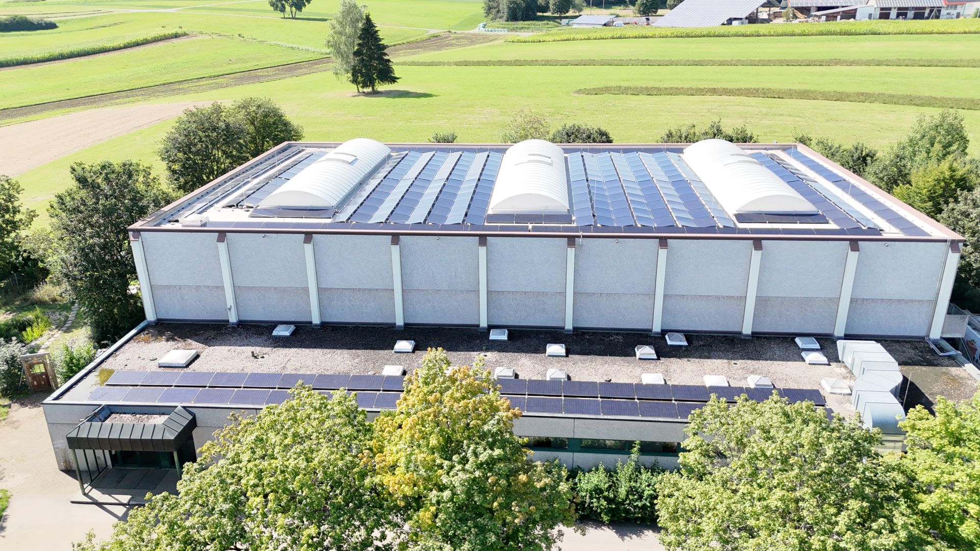 Photovoltaik-System auf einer Sporthalle im Sonnenschein